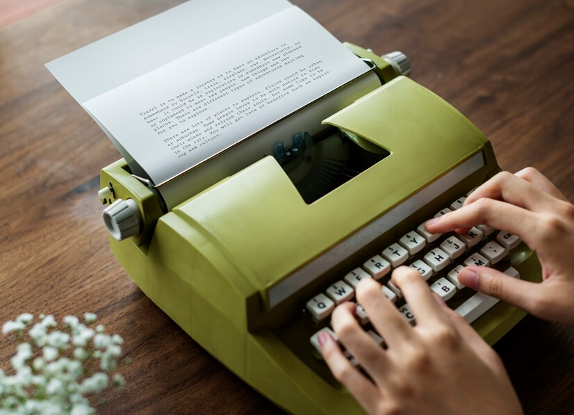 Person using green typewriter to type